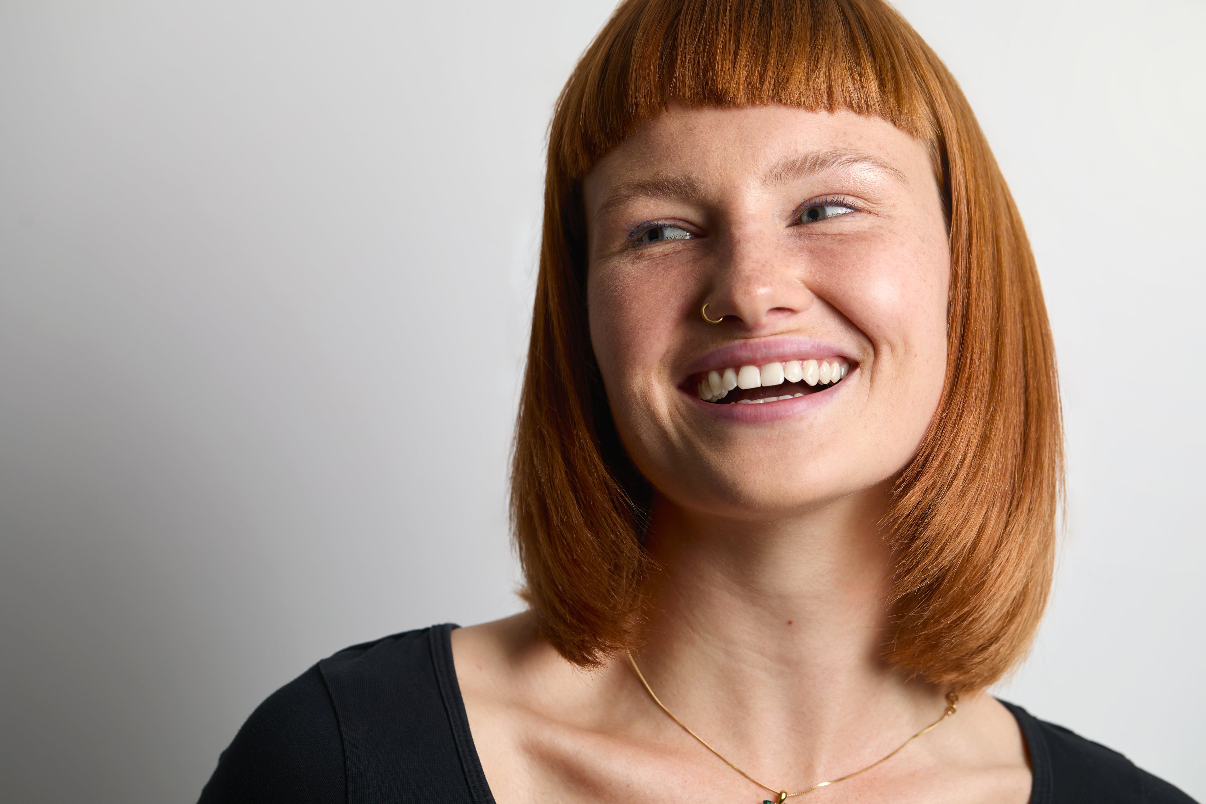 Na zdjęciu uśmiechnięta kobieta o rudych włosach