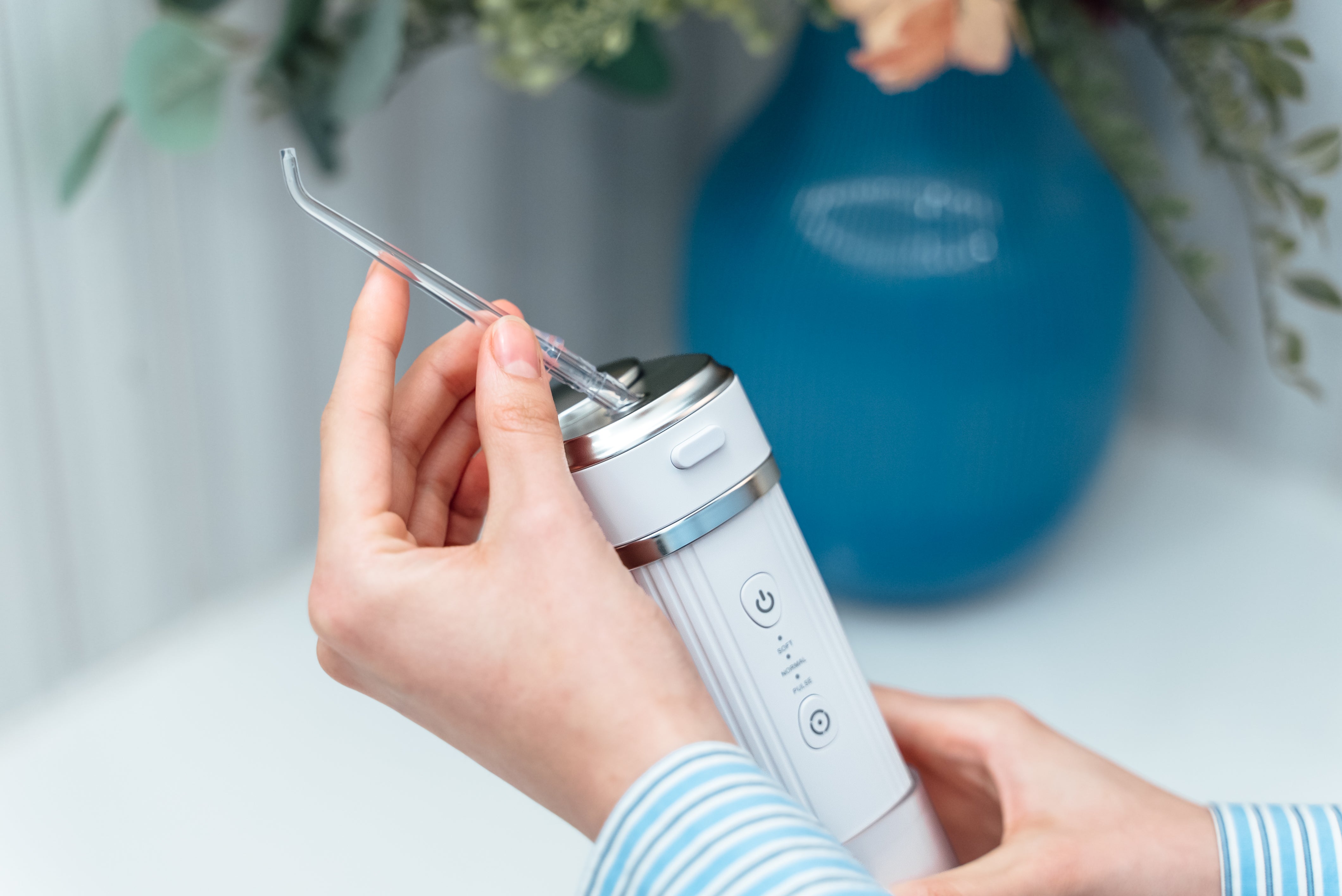 Kobieta trzyma w rękach irygator stomatologiczny do zębów ZENT® Stream+ 